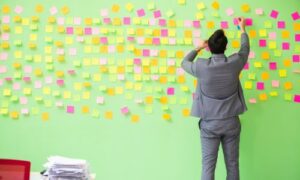 an executive filling a wall with post it notes