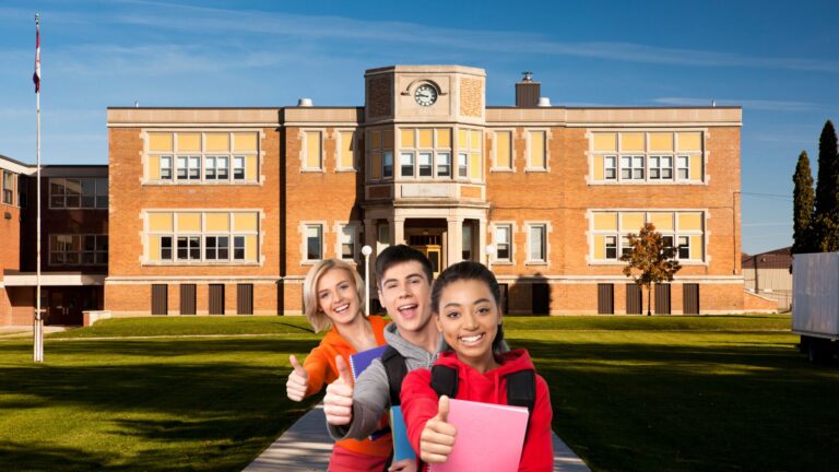 three students posing in front of a high school as they prepare to transition
