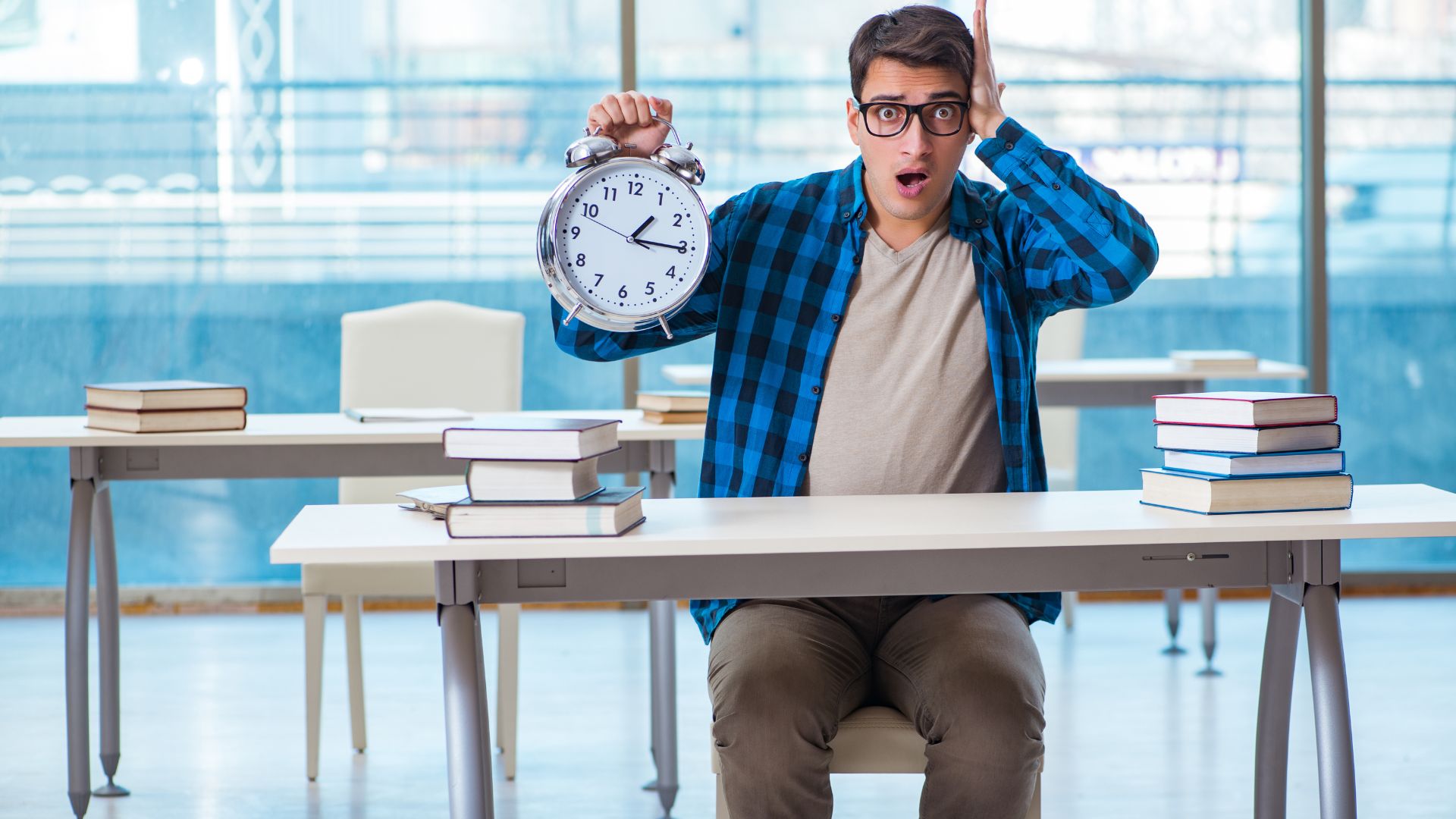 a college student sitting at a table with books while holding a clock and seemingly overwhelmed by a lack of time management skills