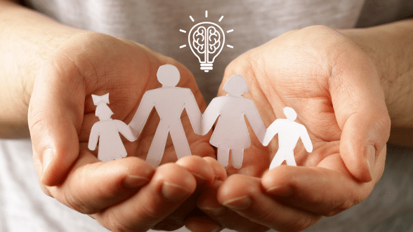 Hands gently holding paper-cut figures of a family with a lightbulb and brain icon above, symbolizing thoughtful boundaries and care.