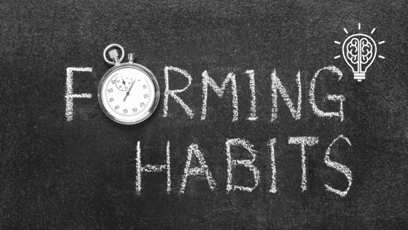 Chalkboard with the phrase 'forming habits', where the letter 'o' in 'forming' is represented as a clock, symbolizing time and habit formation.