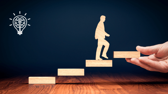 Person stepping onto the next level of a staircase with the help of a hand, symbolizing leadership coaching and development.