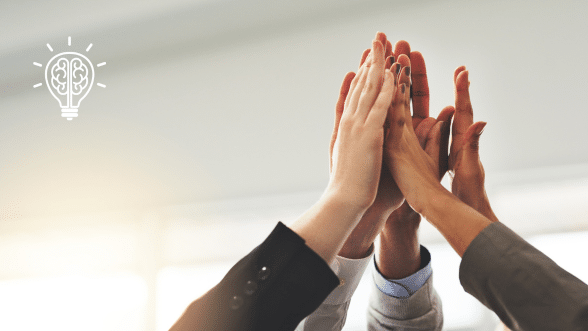 Close-up of diverse hands joining together in a high-five, symbolizing teamwork, collaboration, and organizational success.