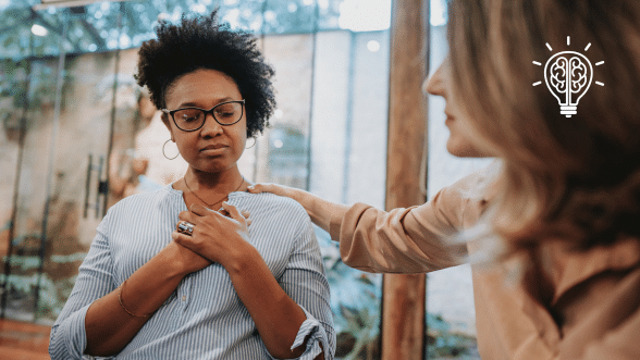 A woman with her hand close to her chest and eyes closed, practicing emotional regulation and mindfulness to manage her emotions.