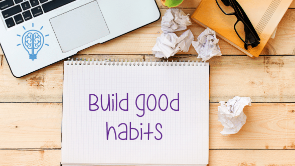 A notebook on a desk with the words "Build good habits" written on it, representing habit tracking.