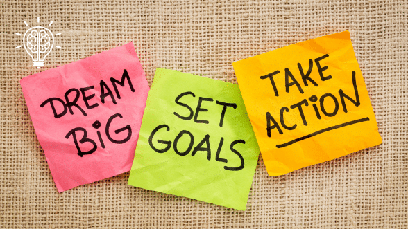 Post-it notes reading 'Dream Big,' 'Set Goals,' and 'Take Action,' representing goal visualization and achievement.