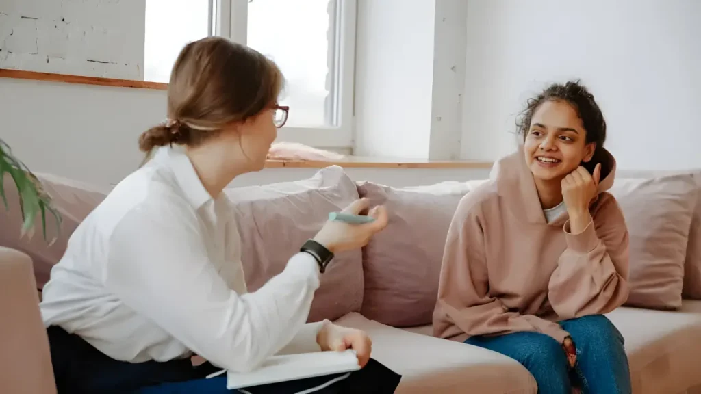 ADHD coach engaging a teenage student in a strategy session to build self-advocacy and executive function skills in a supportive, non-judgmental environment.