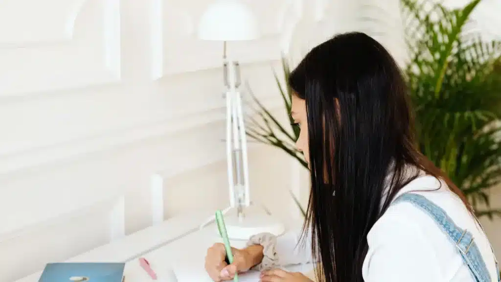 Student sitting at a distraction-free desk writing in a notebook, demonstrating the planning phase of adhd routine building.