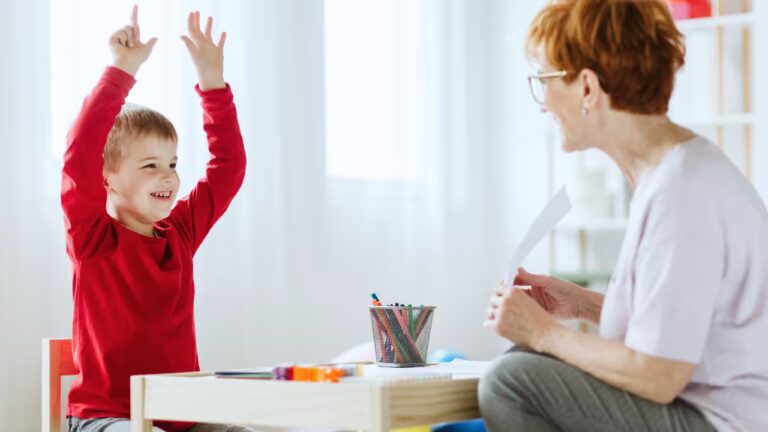 An elementary student celebrating a learning breakthrough with his instructor, showcasing the confidence-building benefits of adhd coaching for executive function skills.