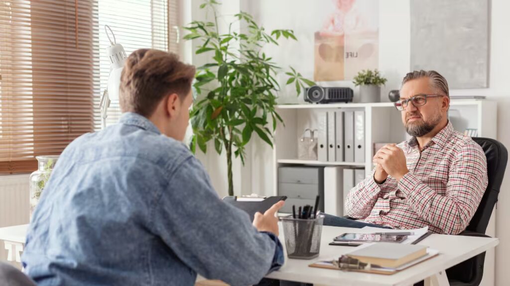 A professional conducting a one-on-one consultation with a male client, exemplifying the personalized, face-to-face approach of New Frontiers' adhd coaching for executive function skills.